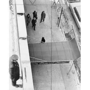 1965 photo Policeman maintains watch from roof of Unity funeral home 