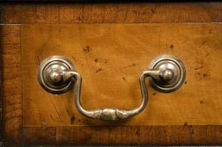 Solid brass swan neck pulls adorn the burl walnut drawer fronts, which 