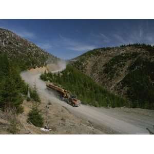  Log Trucks Carry Old Growth Logs Down a Mountain Stretched 